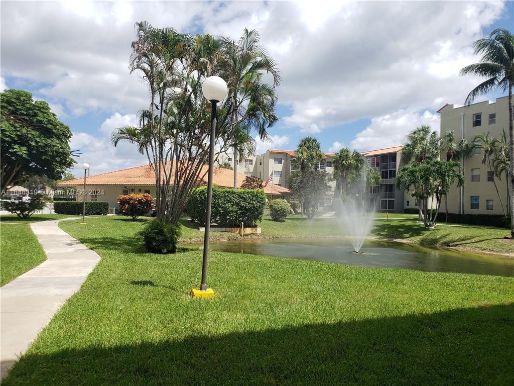 a view of a fountain in front of a house with a big yard