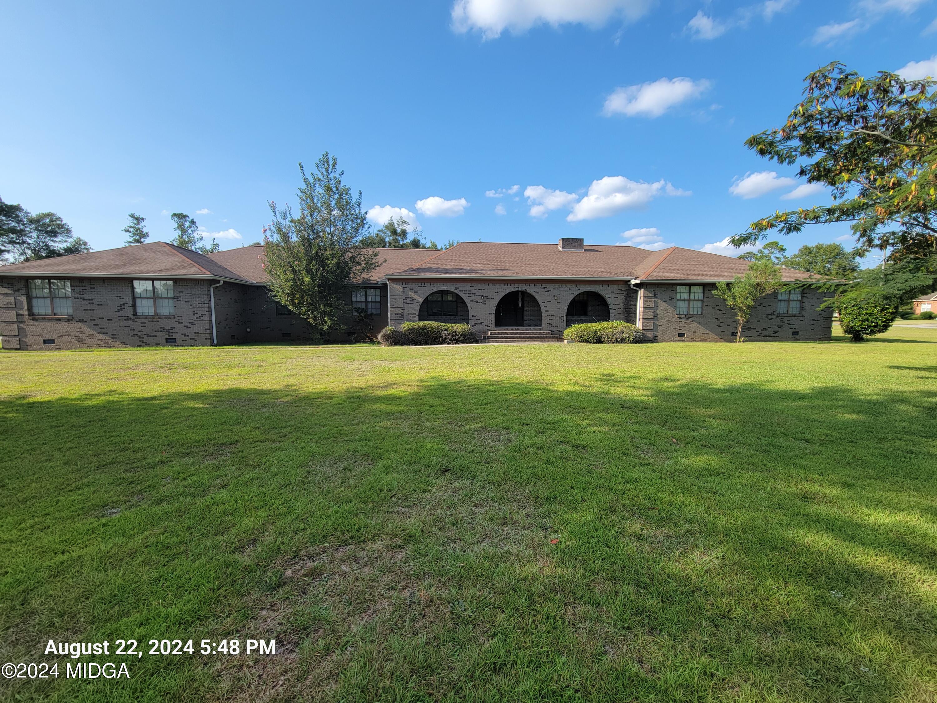 a front view of a house with a yard and trees