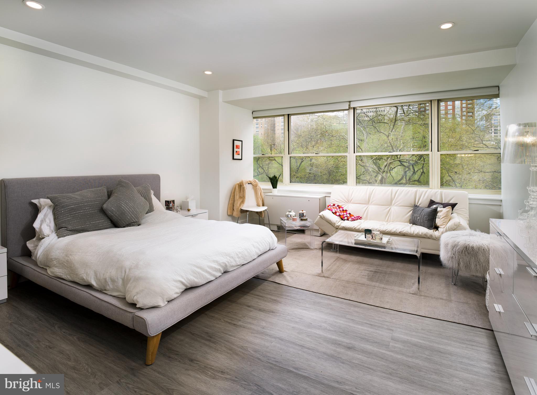 a bedroom with a bed and a large window