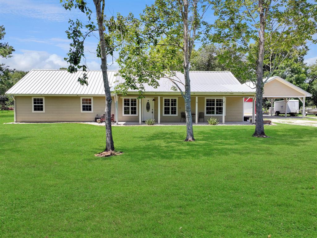 a front view of house with a garden and trees