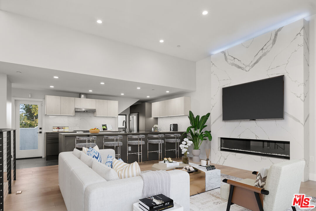 a living room with stainless steel appliances a flat screen tv and a living room view