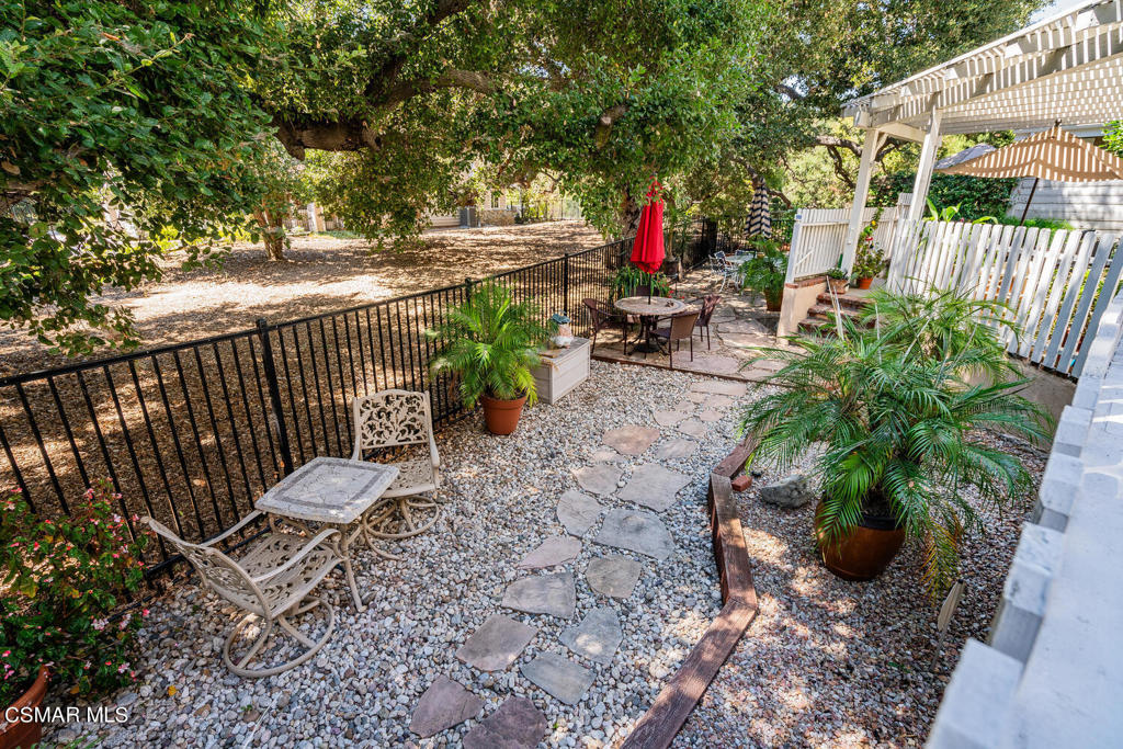 a roof deck with table and chairs and potted plants