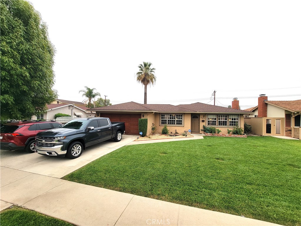 a car parked in front of a house with a yard