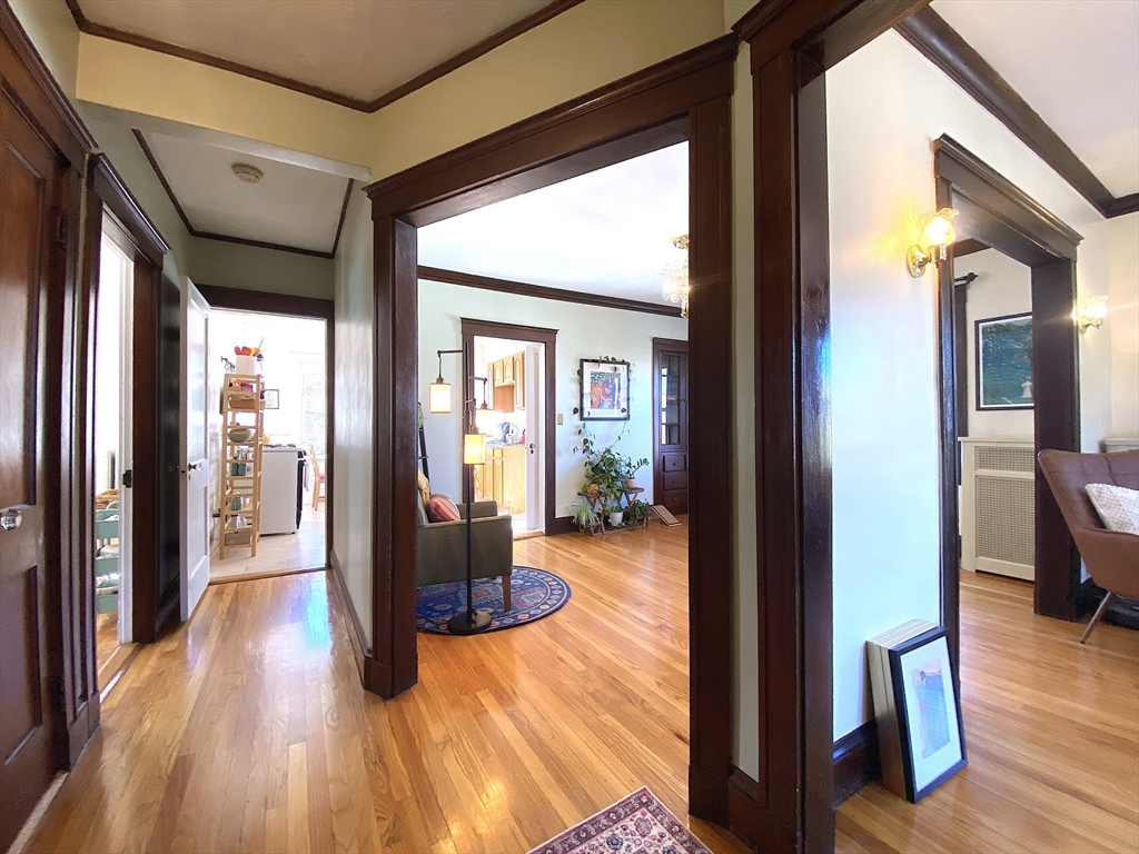 a view of a hallway with wooden floor and windows