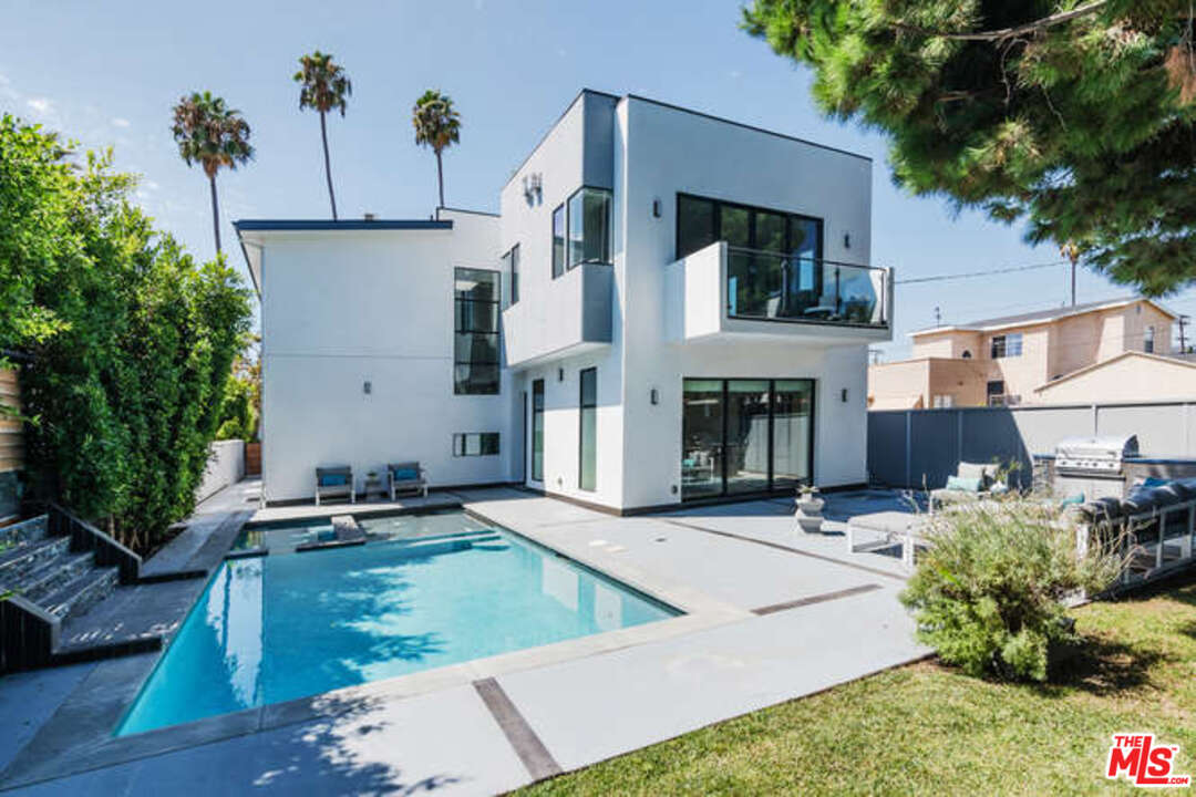 a view of a house with pool and sitting area