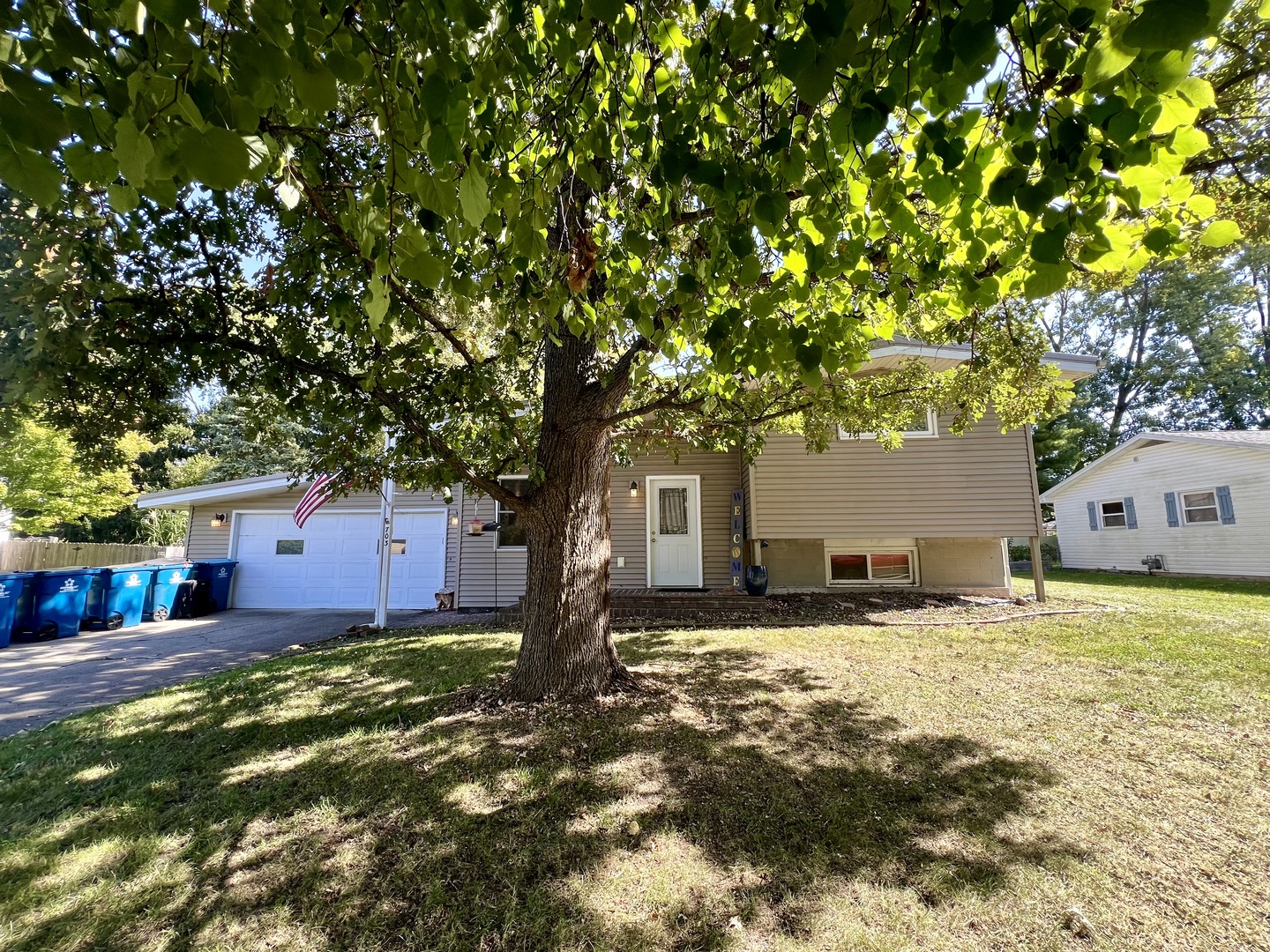 a front view of a house with a yard and trees