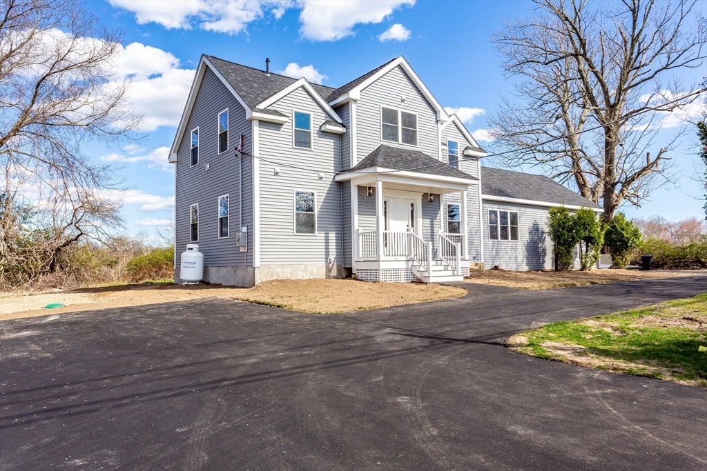 a front view of a house with yard and road