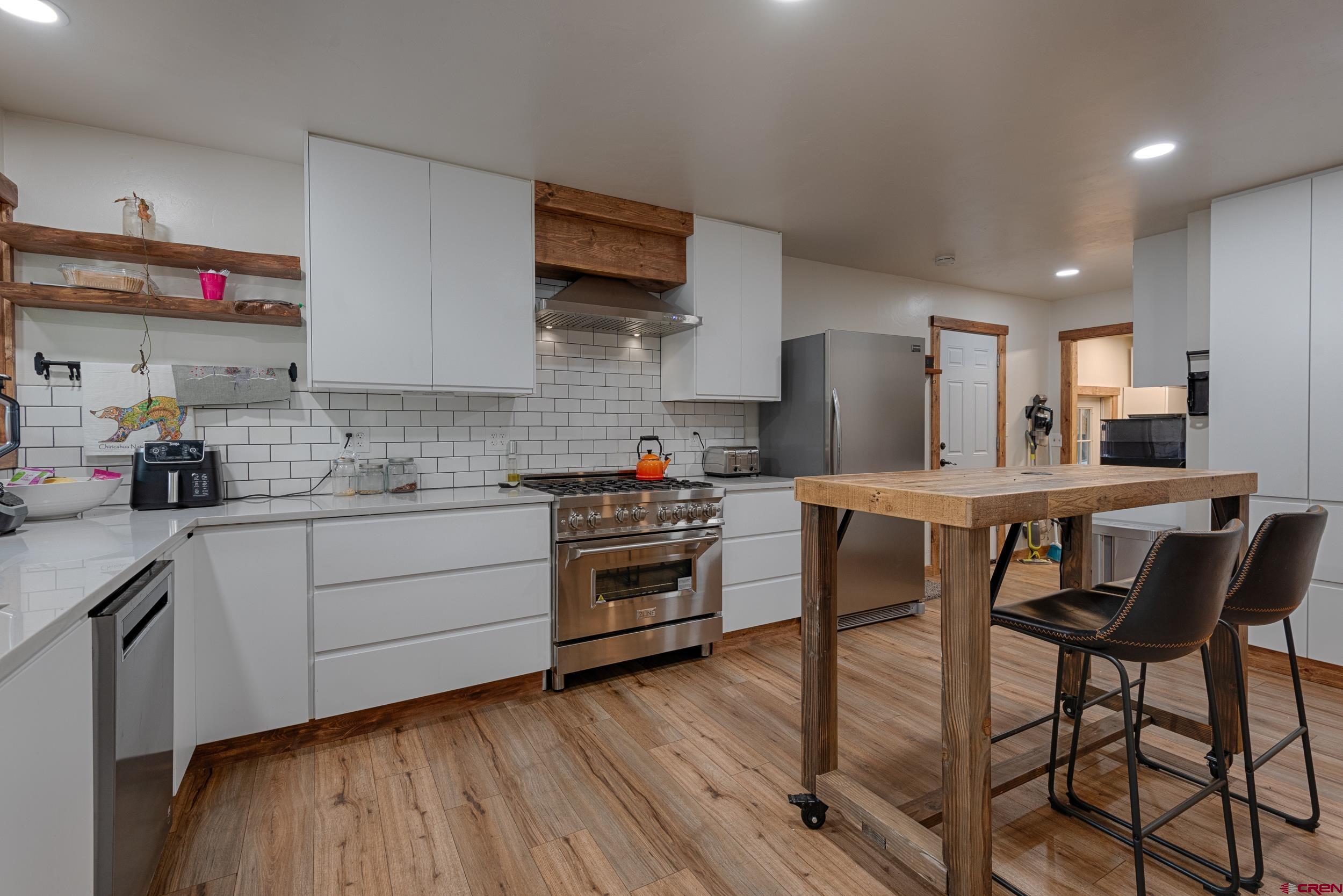 a kitchen with stainless steel appliances a stove a sink dishwasher and a refrigerator