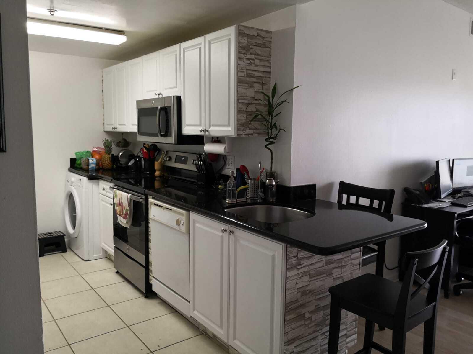 a kitchen with stainless steel appliances granite countertop a sink a microwave cabinets and a stove