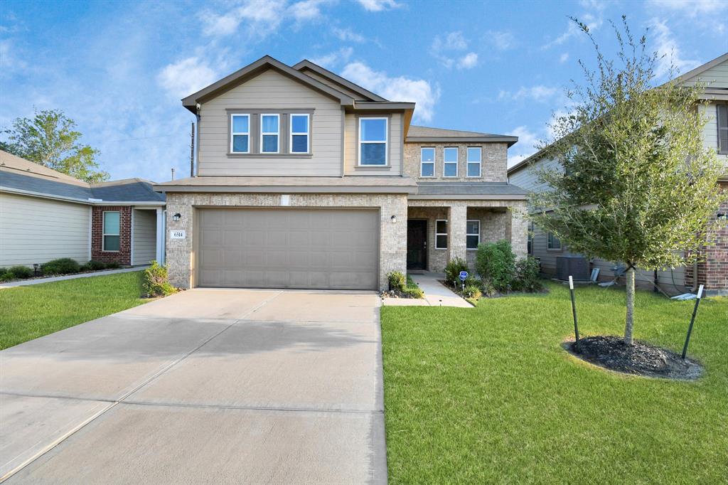 a front view of a house with a yard and garage