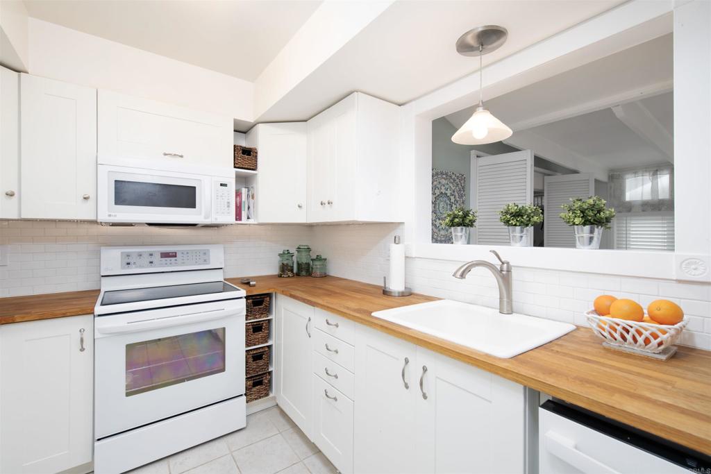 a kitchen with stainless steel appliances granite countertop a sink and cabinets with wooden floor