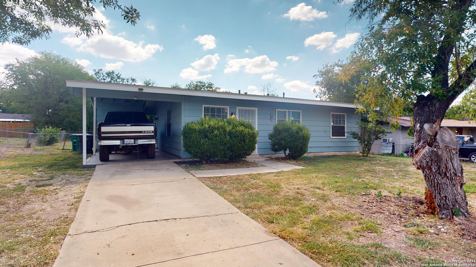 a view of a house with backyard and sitting area