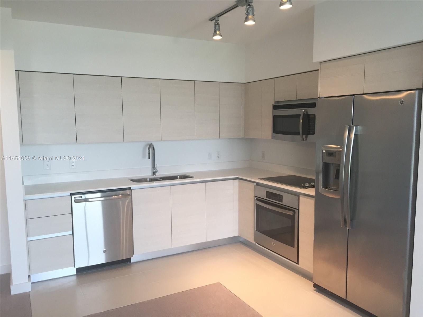 a kitchen with stainless steel appliances white cabinets and a granite counter tops