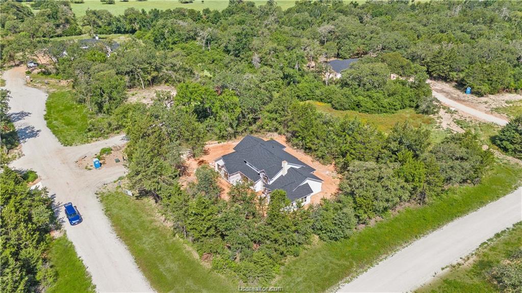 an aerial view of a house with a yard and trees