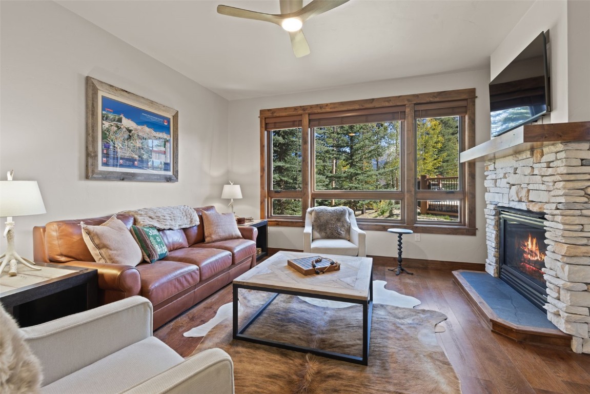 a living room with furniture a large window and a fireplace