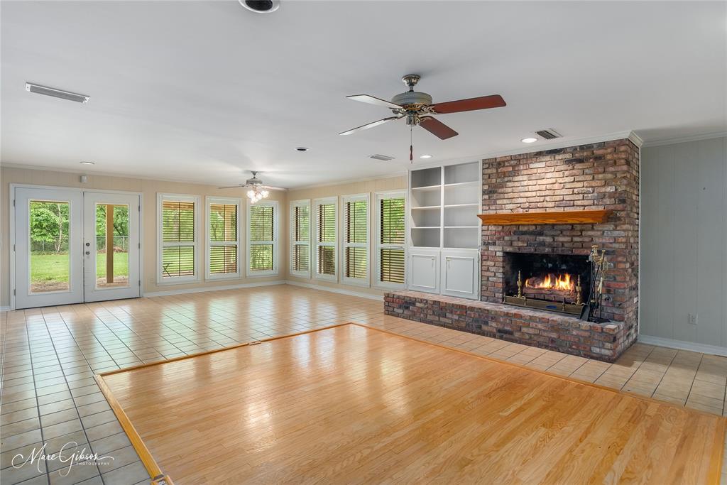 a view of an empty room with a fireplace and a window