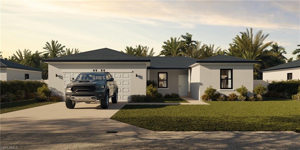 View of front of house with a yard and a garage