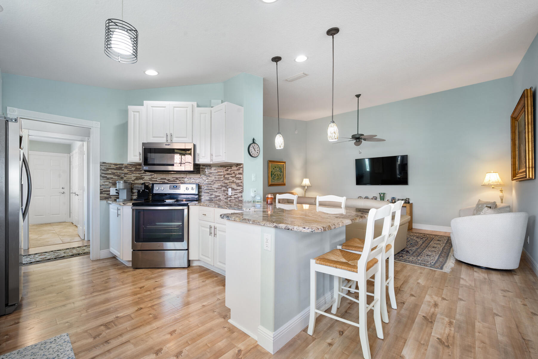 a kitchen with kitchen island white cabinets and stainless steel appliances