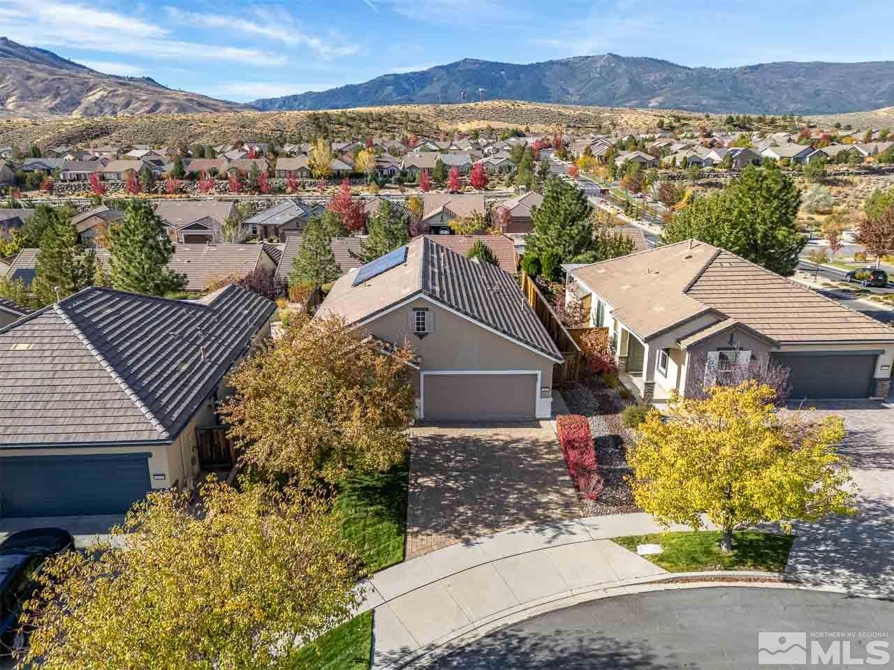 an aerial view of residential houses with outdoor space and trees