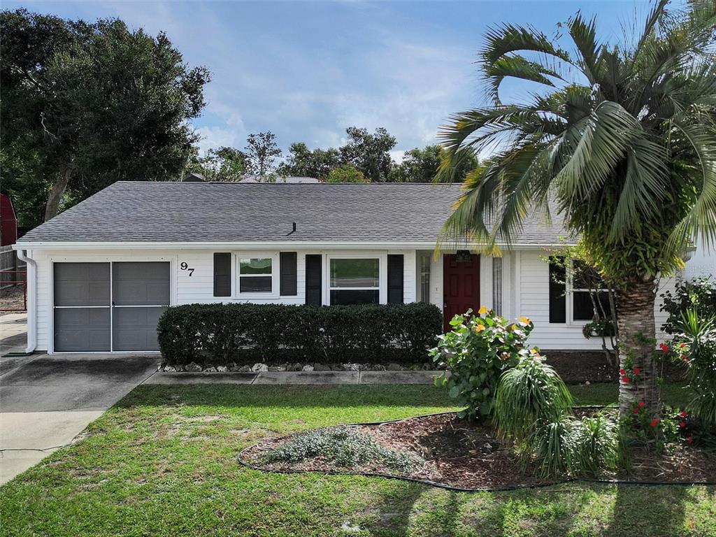 a front view of a house with a garden