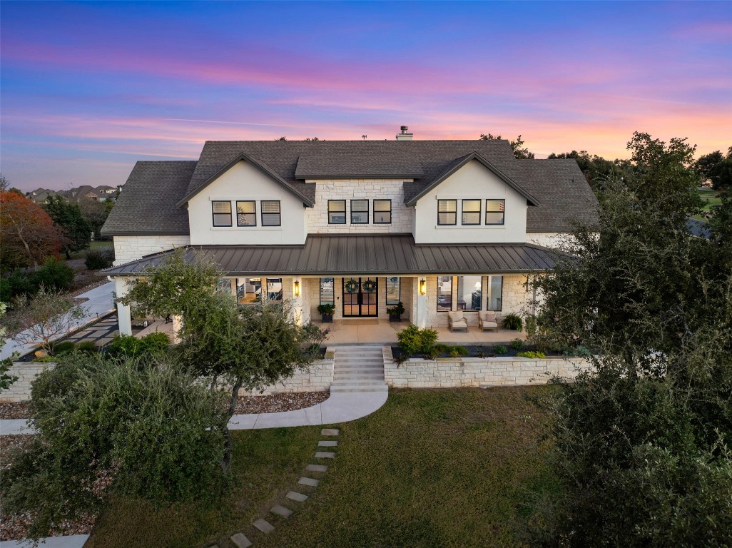 a view of a big house with a big yard and large trees