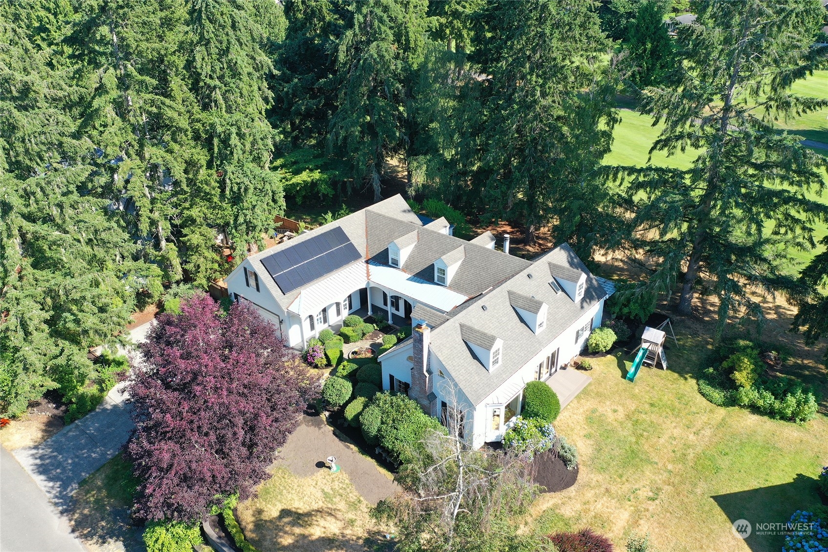 an aerial view of a house with a yard and trees