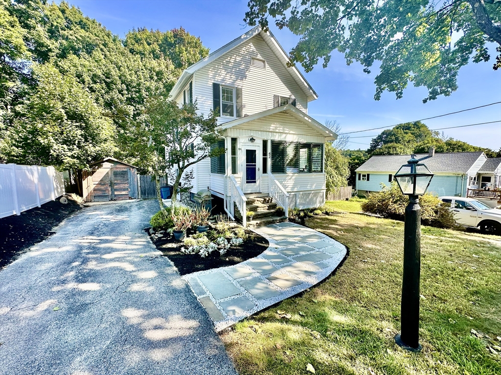 a front view of a house with yard and sitting area