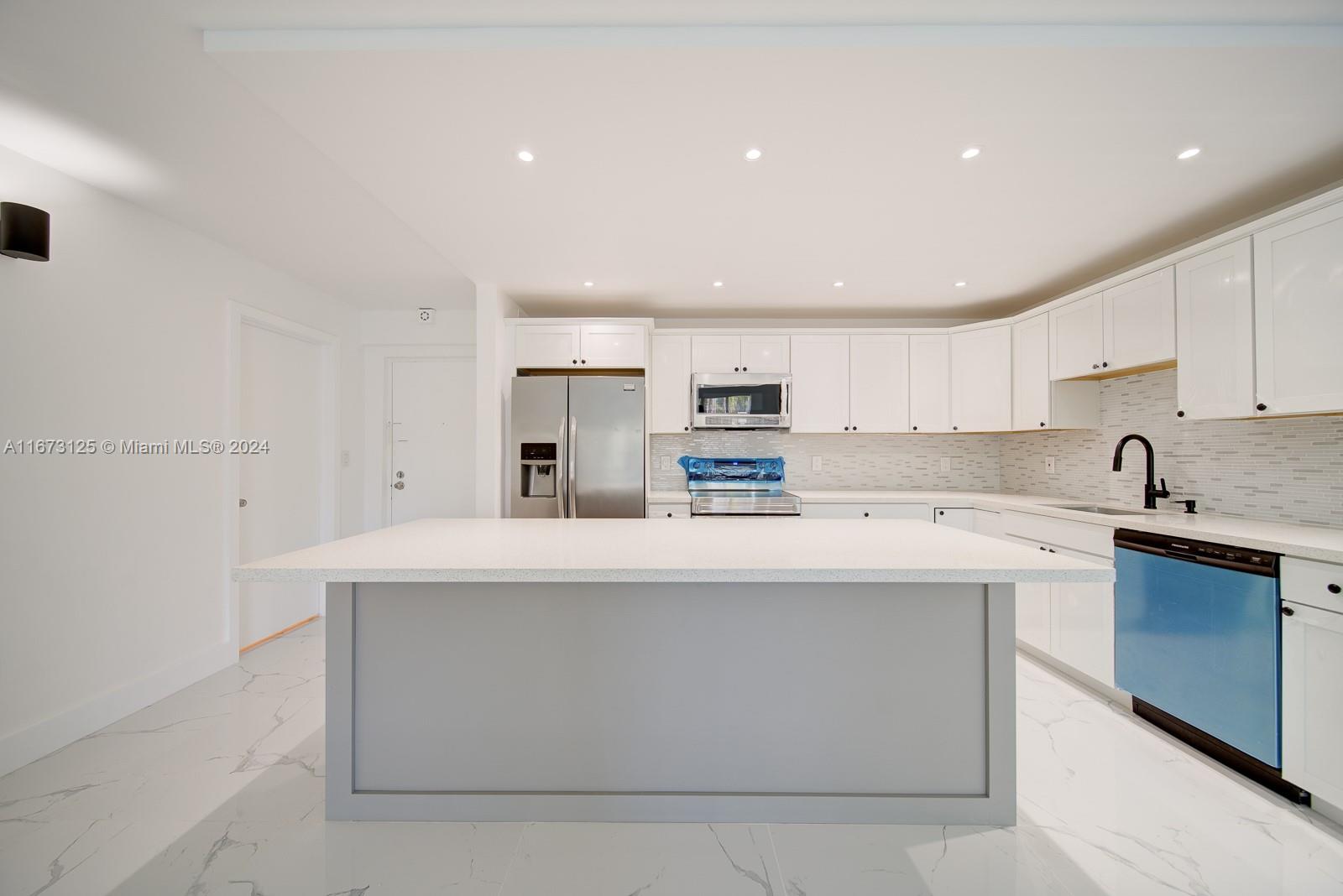 a kitchen with stainless steel appliances a sink stove and white cabinets