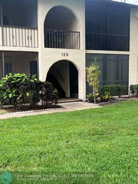 a view of house with yard and outdoor seating