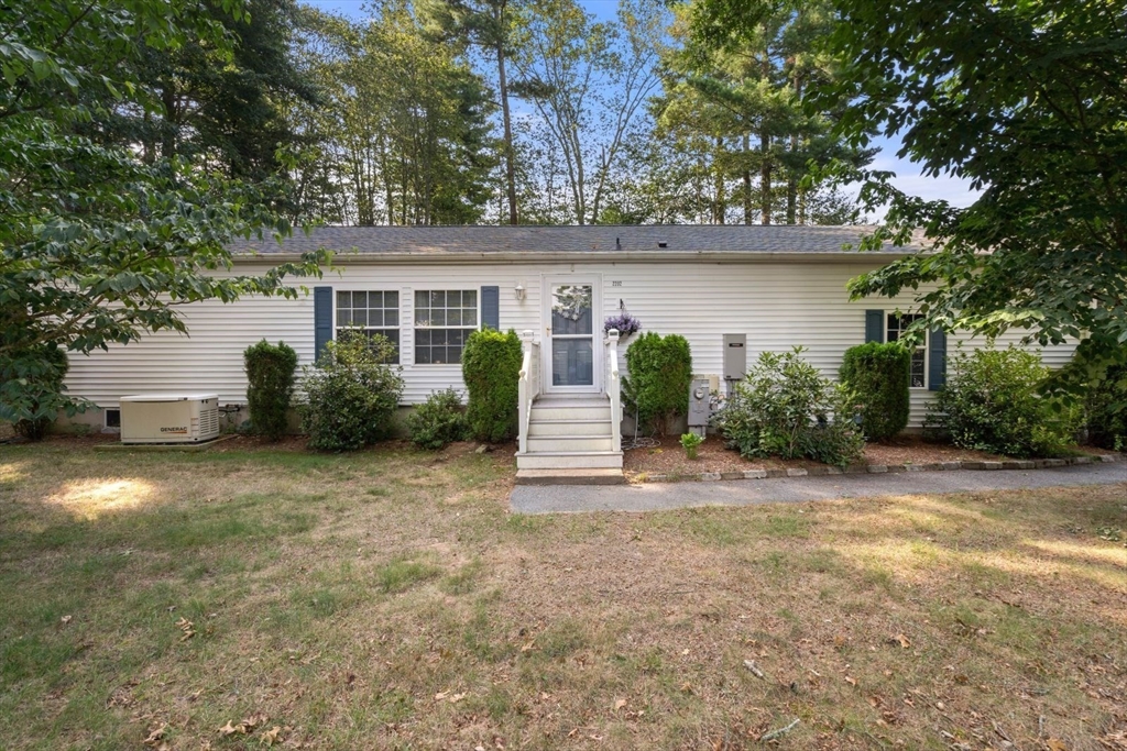 front view of a house with a yard and an trees