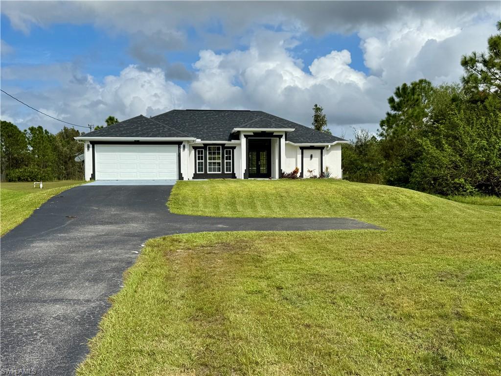 a front view of a house with a yard and garage