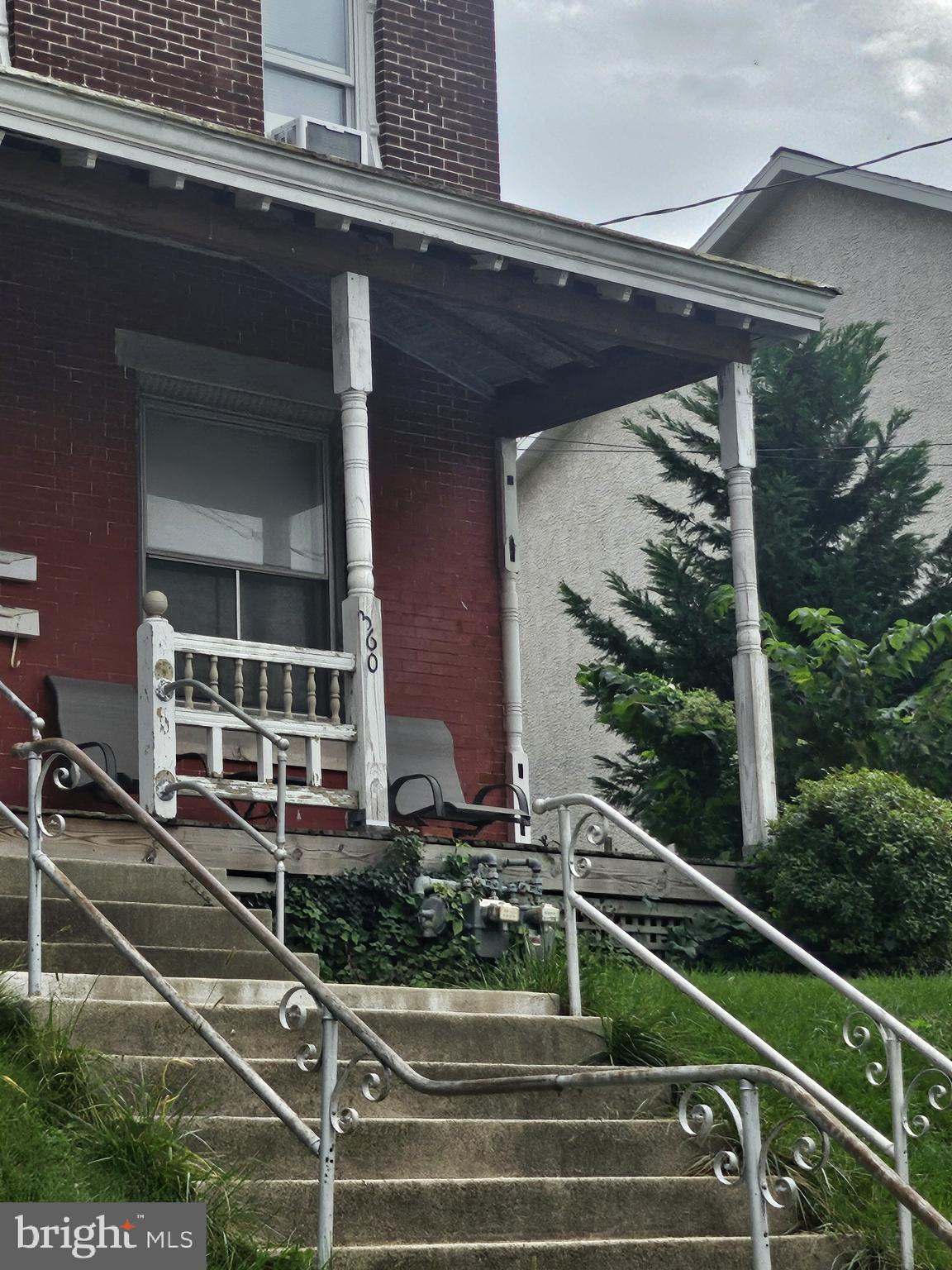 a view of a house with a large window and potted plants