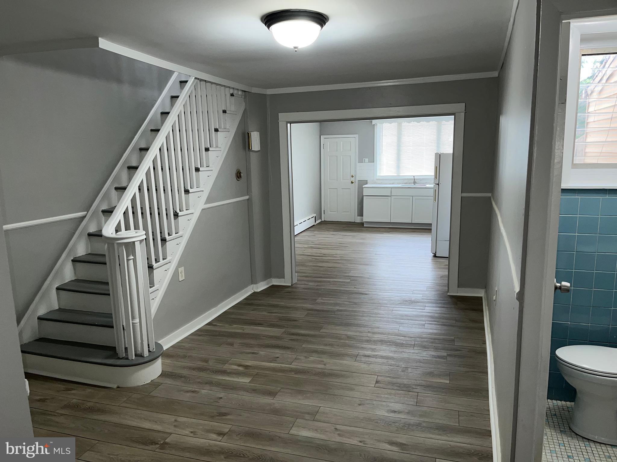 a view of entryway and hall with wooden floor