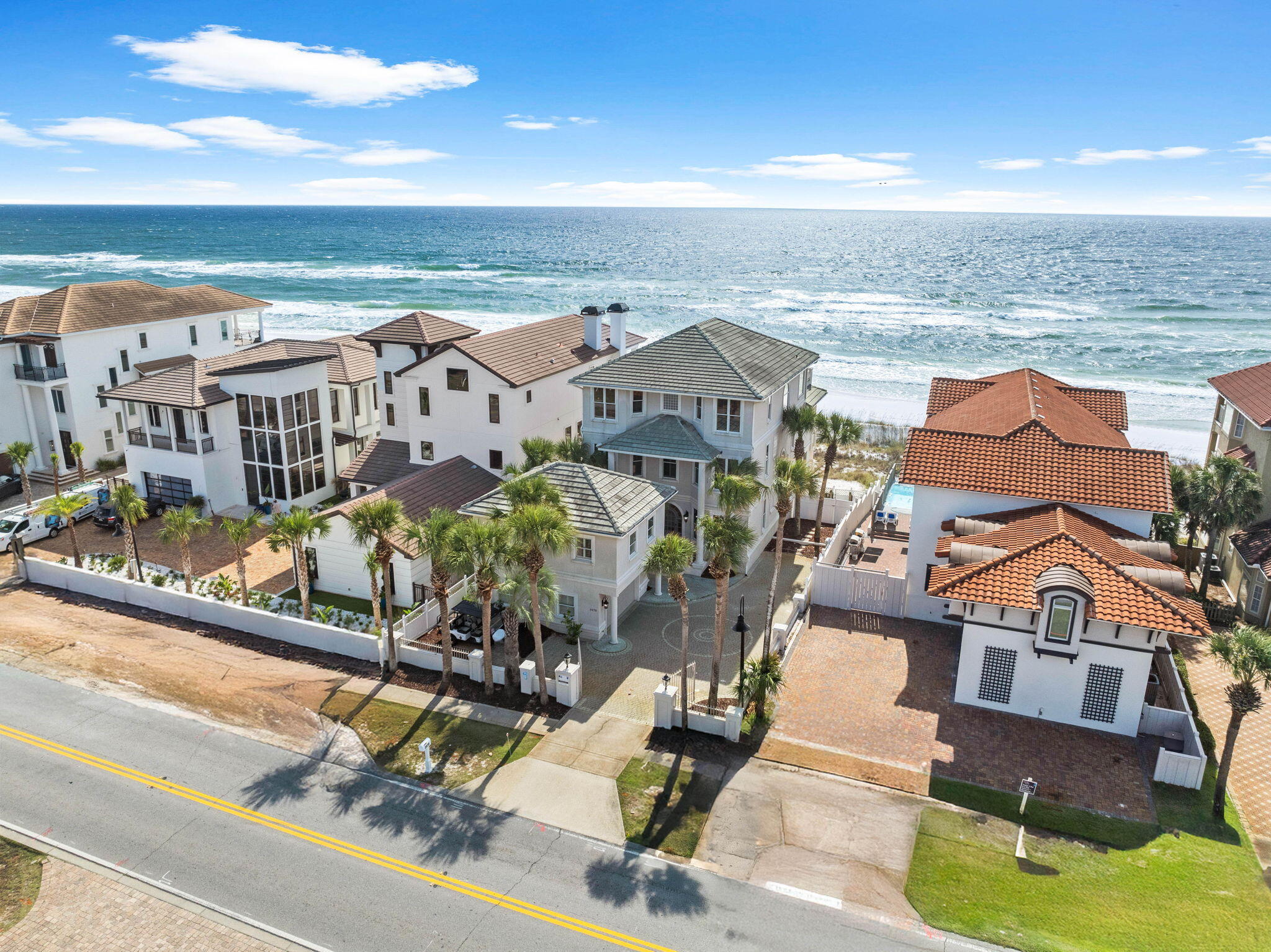 an aerial view of residential houses with outdoor space and ocean view