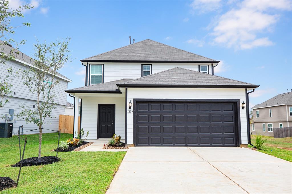 a front view of a house with a yard and garage