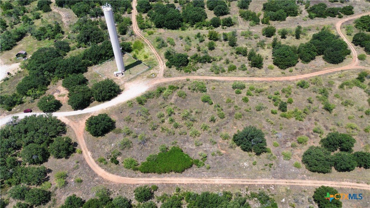 an aerial view of a house with a yard and trees all around