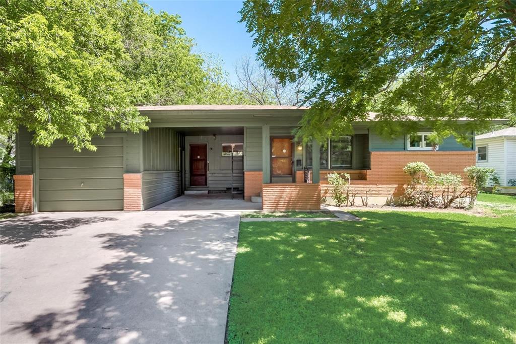 a front view of a house with a yard and trees