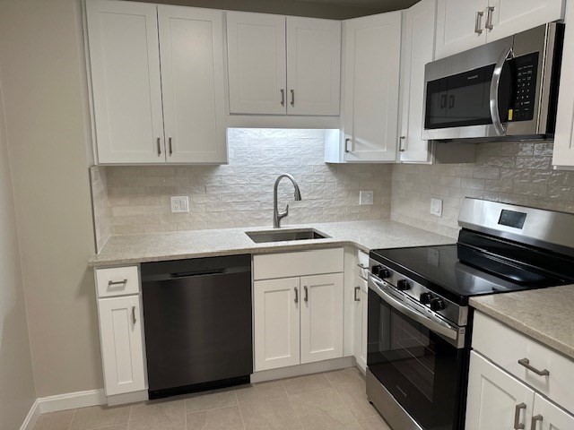 a kitchen with granite countertop white cabinets and stainless steel appliances