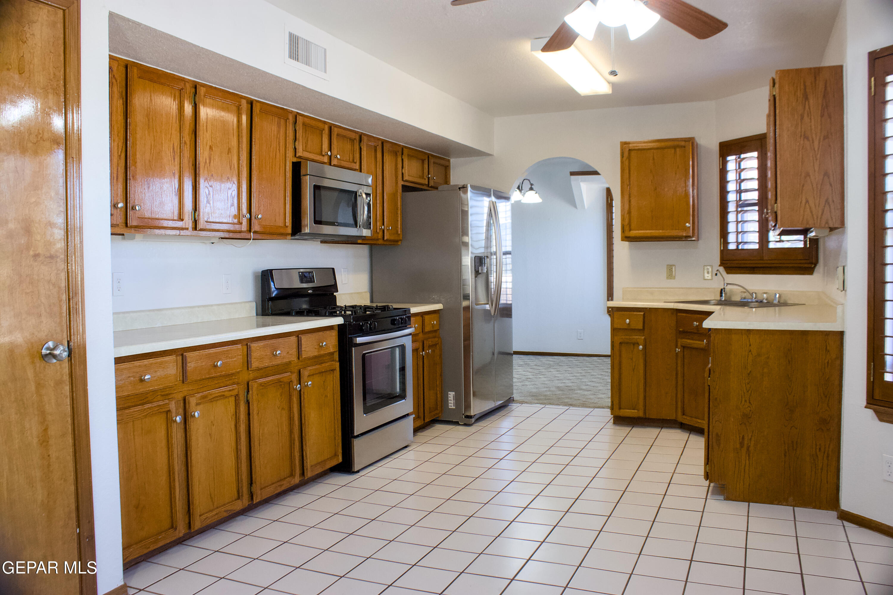 a kitchen with stainless steel appliances granite countertop a refrigerator and a stove top oven