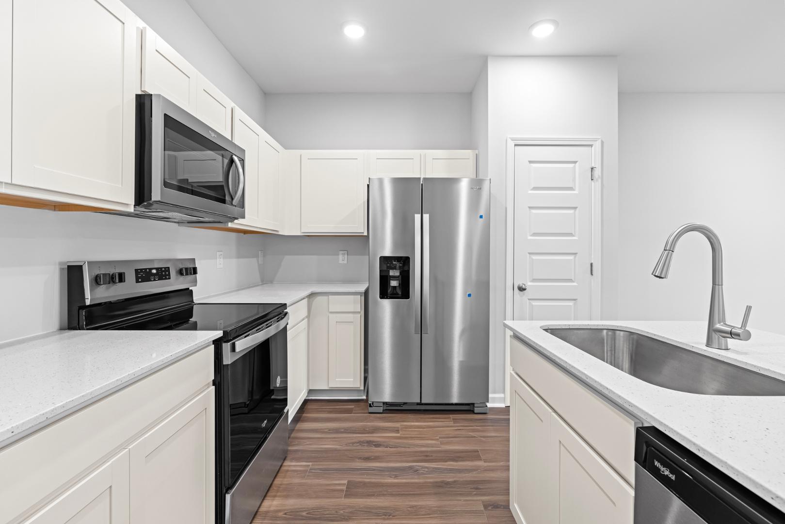 a kitchen with stainless steel appliances granite countertop a refrigerator stove and sink