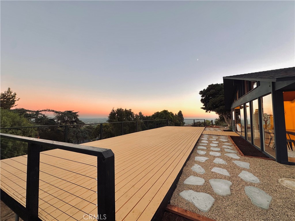 a view of a balcony with wooden floor and fence