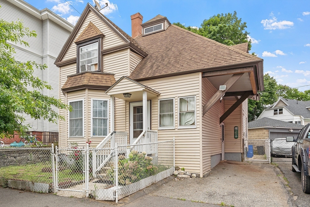 a view of a house with a yard and potted plants