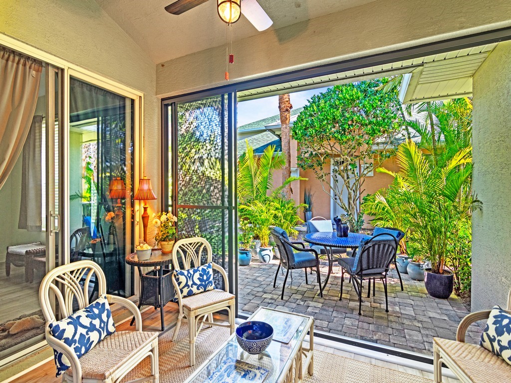 a living room with patio furniture and a large window