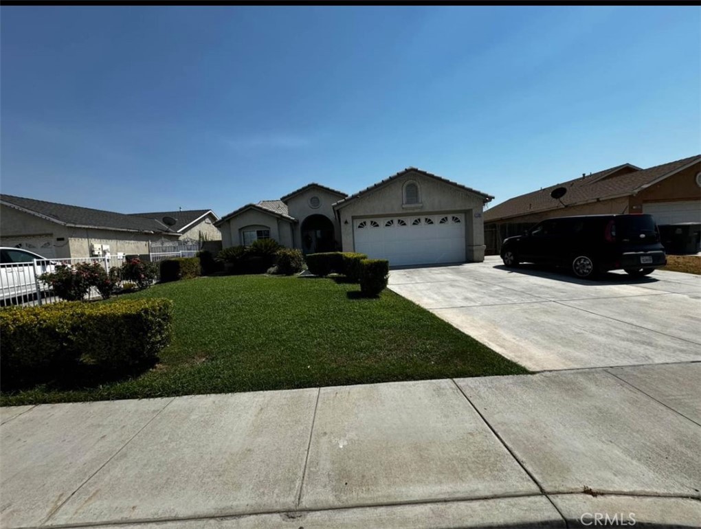 a view of house with yard and car parked