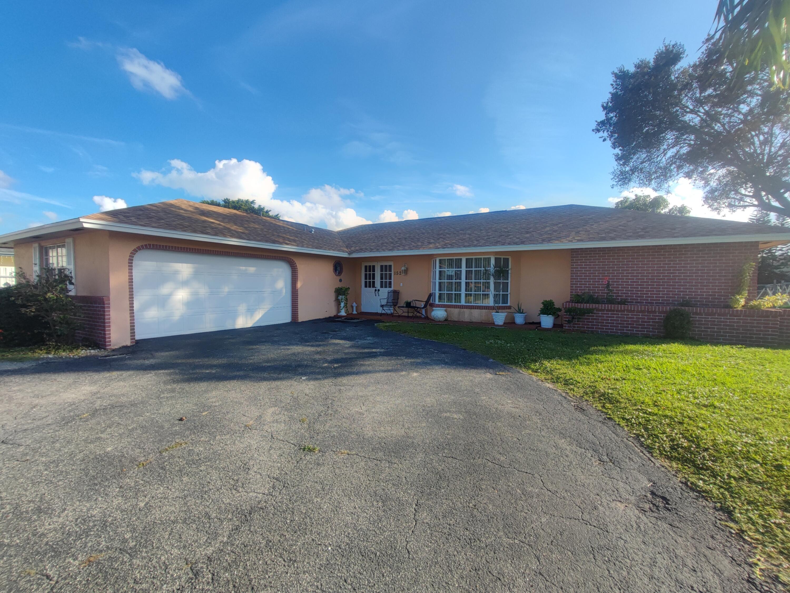 a view of a house with a yard and a garage