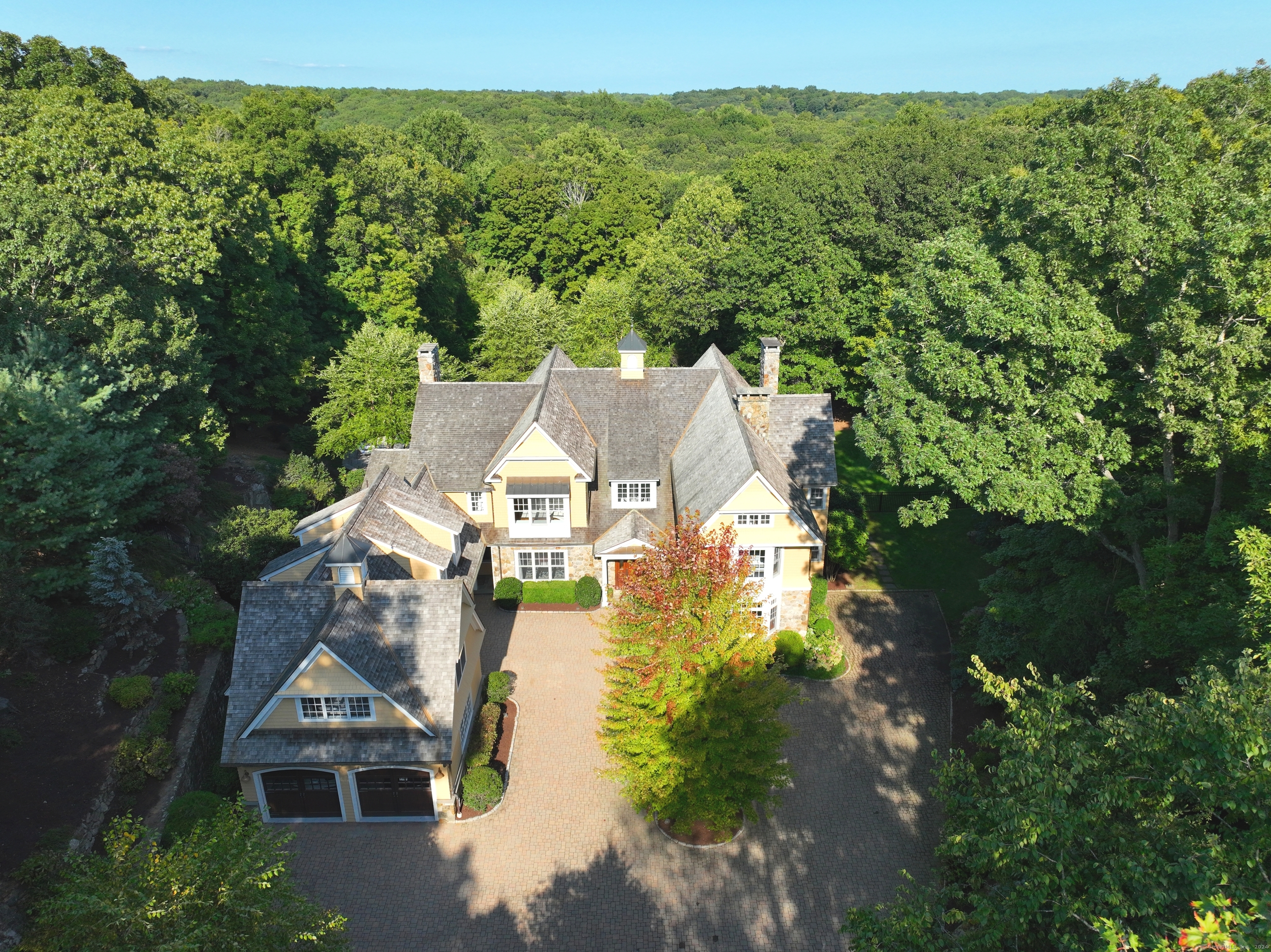 an aerial view of residential houses with outdoor space and trees