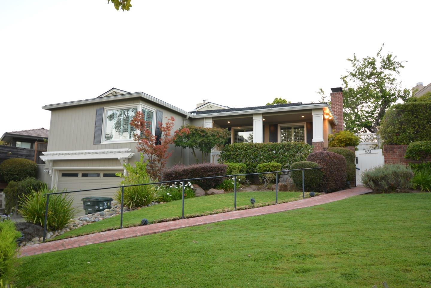 a front view of a house with a garden and plants