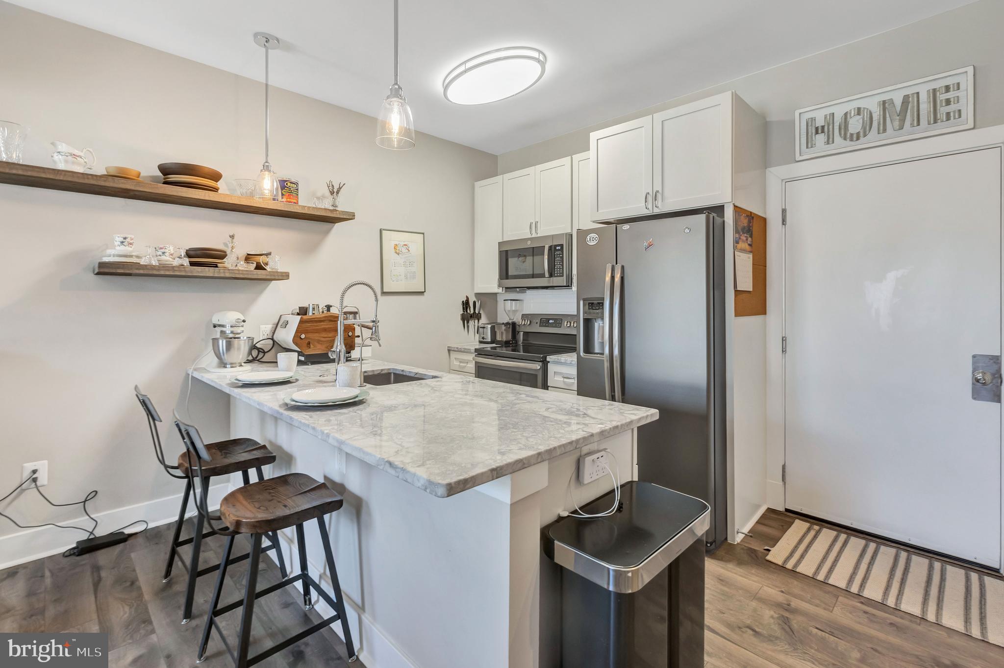 a kitchen with stainless steel appliances a refrigerator a sink and a stove