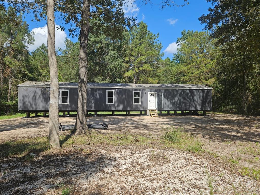 a view of a house with backyard and trees