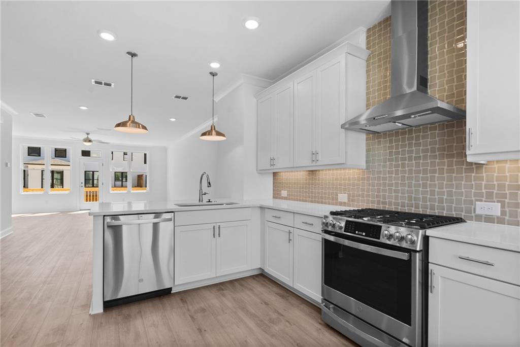 a kitchen with stainless steel appliances granite countertop a stove a sink and a microwave